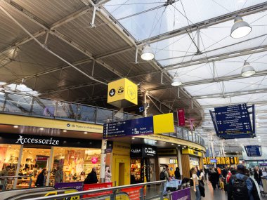 Manchester, İngiltere - 07 Kasım 2025: Tren ve mağazalar arasında gezinen dükkanlar, işaretler ve gezginlerle dolu Manchester istasyonu