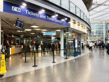 Manchester, İngiltere - 07 Kasım 2025: Manchester seyahat merkezi bilet masaları, kuyruklar ve modern cam iç mekan.