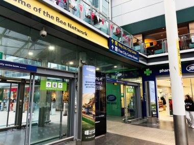 Manchester, İngiltere - 07 Kasım 2025: Manchester şehir merkezi transit levhaları, dükkanlar ve cam mağazalarda bir eczane ile meşgul.