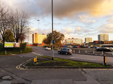 Salford, UK - November 08, 2025: Urban street scene in Salford at dusk showing cars, buses, modern flats and a cloudy sky.