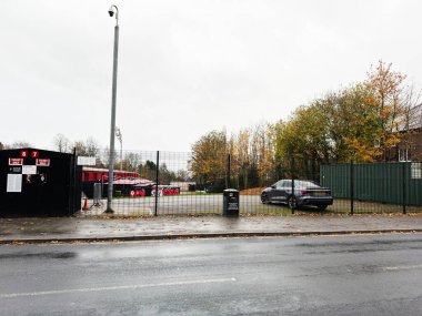 Manchester, UK - November 09, 2025: A security camera overlooks a gated car park bordered by autumn trees in Manchester today.