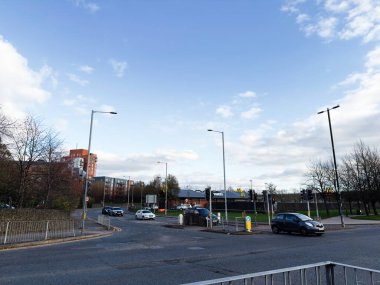 Manchester, UK - November 16, 2025: Urban street view in Manchester featuring traffic, modern buildings, and a McDonalds in the distance.