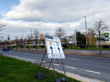 Manchester, İngiltere - 16 Kasım 2025: Manchester Stadyumu yakınlarındaki turuncu ve mavi yollarda trafiğe rehberlik eden sokak tabelası.