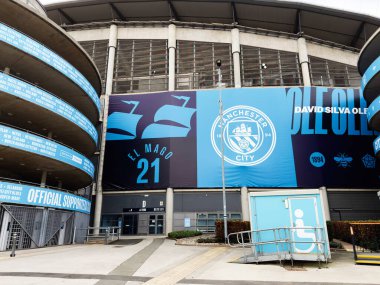 Manchester, İngiltere - 16 Kasım 2025: Manchester 'ın girişinde büyük mavi bir bayrak ve erişilebilirlik özellikleri bulunan stadyum dışı.