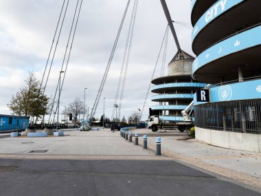 Manchester, İngiltere - 16 Kasım 2025: Manchester Stadyumu 'nun dış görünüşü mavi halka, kablo ve açık plazayı gösteriyor.