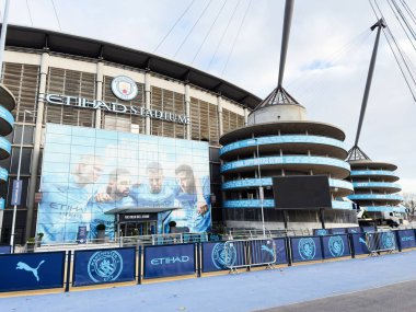 Manchester, İngiltere - 16 Kasım 2025: Manchester City Stadyumu 'nda mavi markalı, sancaklı ve kendine özgü dairesel kuleleri olan modern bir stadyum..