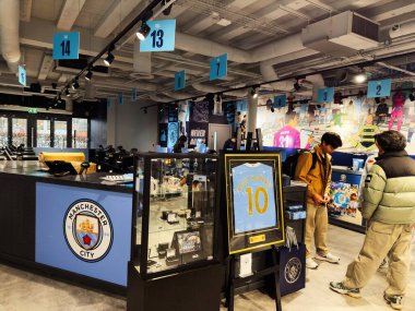 Manchester, İngiltere - 16 Kasım 2025: Manchester City 'de bir mağazanın içinde, taraftarlar stadyum dükkanında forma ve ürünlere göz atıyorlar.