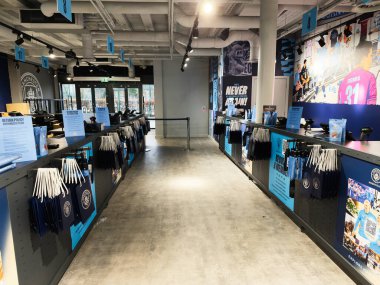 Manchester, İngiltere - 16 Kasım 2025: Mavi markalı ve aksesuarlı canlı stadyum mağazası.