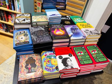 Manchester, İngiltere - 15 Kasım 2025: Bir kitapçı masasında çeşitli başlık ve yazarların canlı bir şekilde sergilenmesi tarayıcılığı ve okumayı davet ediyor.