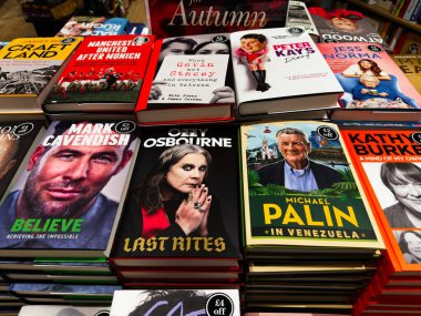 Manchester, İngiltere - 15 Kasım 2025: Yığınlanmış raflarda, renkli kapaklarda ve göz alıcı enerjiyle ünlü anıları ve politik başlıkları bulunan canlı kitapçı sergisi.