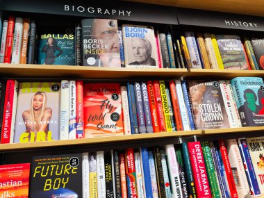 Manchester, İngiltere - 15 Kasım 2025: Biyografi ve tarih başlıkları ile dolu renkli bir kitapçı rafı okumak ve keşfetmek.