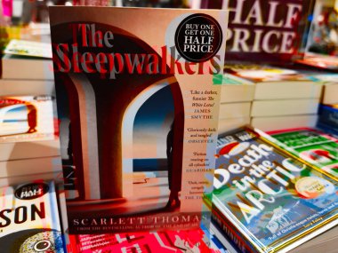 Manchester, İngiltere - 15 Kasım 2025: Renkli kapaklı canlı kitapçı sahnesi ve işlek bir dükkanda indirim tabelası.