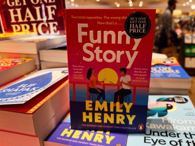 Manchester, İngiltere - 15 Kasım 2025: Emily Henry 'nin Komik Hikayesi' nin yer aldığı parlak kitapçı sahnesi renkli kitaplar ve sıcak ışıklandırma arasında sergileniyor.