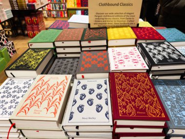 Manchester, İngiltere - 15 Kasım 2025: Renkli giysili klasikler, dekoratif desenler ve zengin dokular sergilenen bir kitapçı masasında düzenlendi.