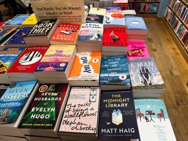 Manchester, İngiltere - 15 Kasım 2025: Yığınla roman ve çok satan kitapçı sergisi, okuyucuları gezmeye ve yeni başlıklar keşfetmeye davet ediyor.