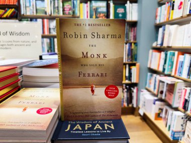 Manchester, İngiltere - 15 Kasım 2025: Robin Sharma 'dan önemli bir kitap kapağı ile sıcak bir kitapçı sahnesi, okuma ve keşfetme davetlisi.