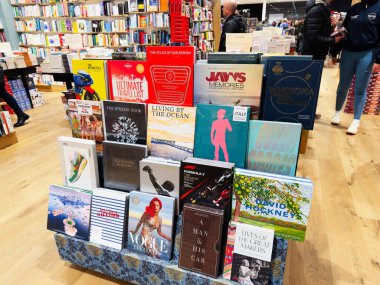 Manchester, İngiltere - 15 Kasım 2025: Seyahat modası ve tasarım başlıkları ile dolu bir kitapçıda renkli kitap standı