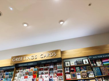 Manchester, İngiltere - 15 Kasım 2025: Renkli tatil tasarımlarının yer aldığı ahşap bir rafta perakende tebrik kartları sergisi.