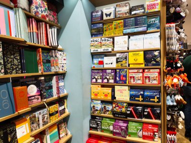 Manchester, İngiltere - 15 Kasım 2025: Dostane bir kitapçıda defter takvimleri ve eğlenceli hediyelerle dolu canlı raflar.