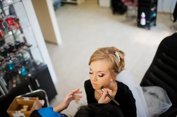 Joven novia rubia aplicando maquillaje de boda por maquillador — Foto de Stock