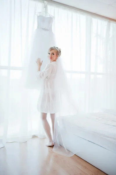 Zachte bruid in jurk keek haar trouwjurk — Stockfoto