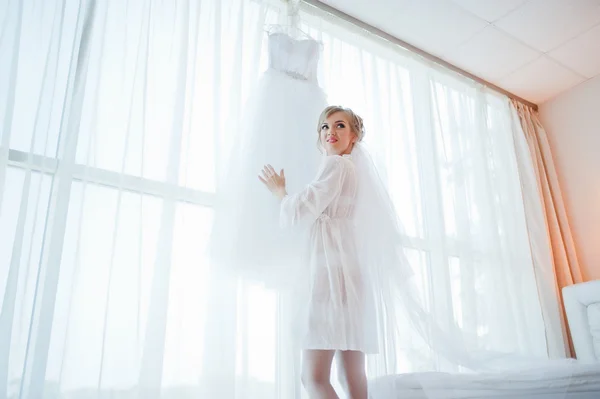 Нежная невеста в платье посмотрел на ее свадебное платье — стоковое фото
