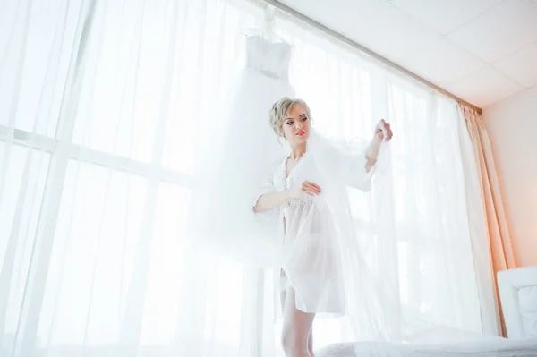 Zachte bruid in jurk keek haar trouwjurk — Stockfoto