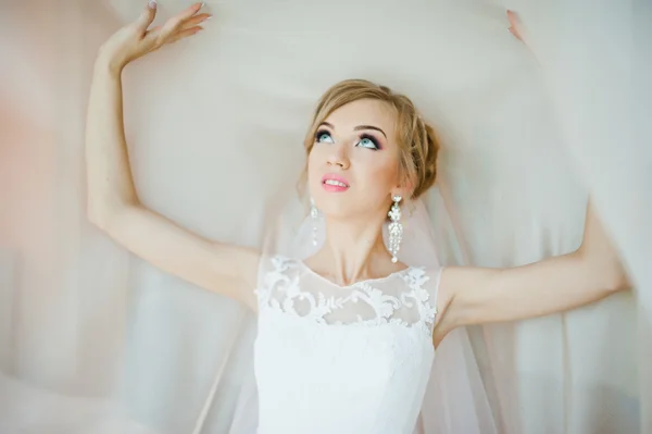 Gentle blonde  bride on curtains tender posed — Stock Photo, Image