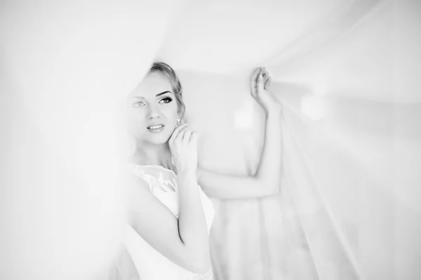 Нежная блондинка невеста на занавесках нежная поза — стоковое фото