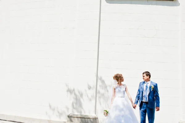 Matrimonio coppia vicino muro di pietra bianca con colonne — Foto Stock