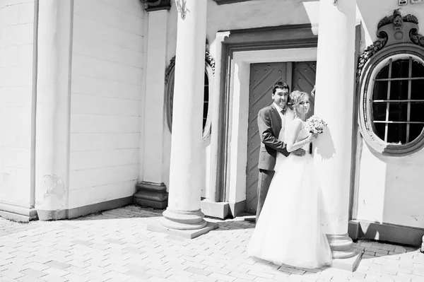 Casamento casal perto de parede de pedra branca com colunas — Fotografia de Stock