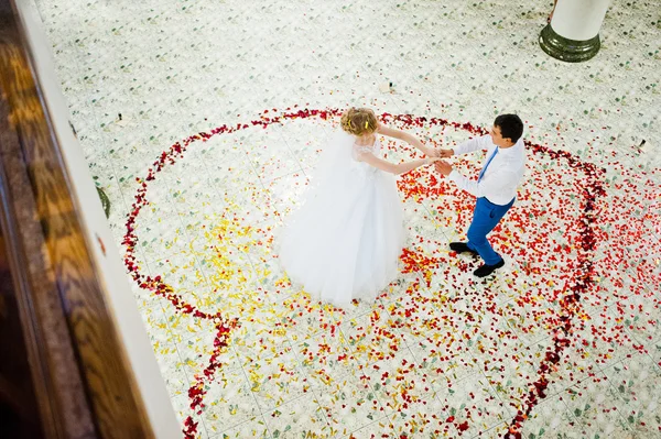 Första bröllop dans av par i kronblad av Ros — Stockfoto