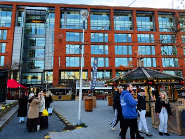 Manchester, İngiltere - 16 Kasım 2025: Yerel halk ve ziyaretçiler, festival ışıkları ve kentsel mimarinin ortasında Manchester 'daki bir Noel pazarını keşfettiler.