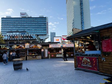 Manchester, İngiltere - 16 Kasım 2025: Manchester 'da canlı pazar sahnesi gıda tezgahları, churros, pasta ve uzun otel binaları.