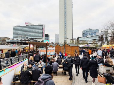 Manchester, İngiltere - 16 Kasım 2025: Manchester 'da tezgahlar, banklar ve kışlık ceketlerle alışveriş yapan insanlar ile canlı pazar sahnesi