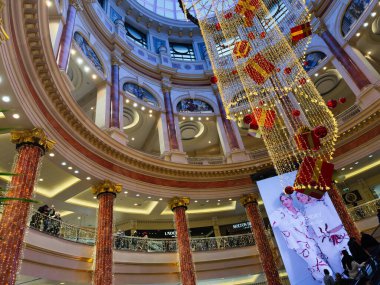 Stretford, İngiltere - 15 Kasım 2025: Süslü sütunlar ve çağlayan ışıkların yer aldığı büyük Manchester AVM Trafford Centre atriyumunda parlak tatil süslemeleri.