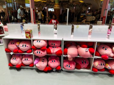 Stretford, İngiltere - 15 Kasım 2025: Manchester Mini mağazasının yakınında müşterileri olan yoğun bir mağazada renkli pembe Kirby pelüş oyuncakları.