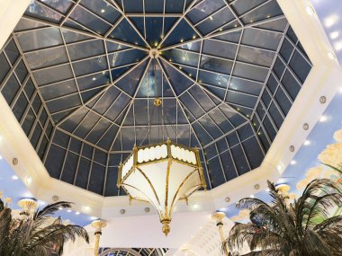 Stretford, İngiltere - 15 Kasım 2025: Şatafatlı Trafford Merkezi cam kubbesi süslenmiş avize ve tropikal bitkiler Manchester Otel lobisinde