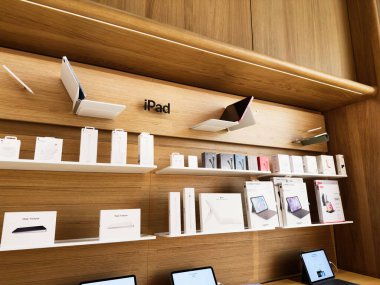 Stretford, İngiltere - 15 Kasım 2025: Manchester 'daki modern teknoloji mağazası iPad cihazlarını ve aksesuarları ahşap raflarda gösteriyor.