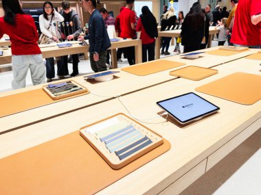 Stretford, İngiltere - 15 Kasım 2025: Müşteriler Manchester 'daki parlak modern teknoloji mağazasında Apple tabletlerine ve aksesuarlarına göz atıyorlar.