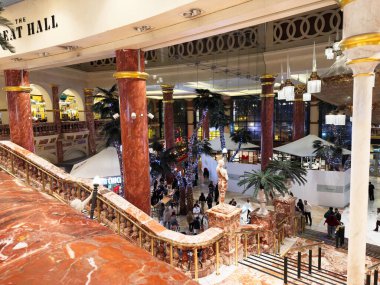 Stretford, İngiltere - 15 Kasım 2025: Manchester 'da mermer merdivenleri, kırmızı sütunları, heykelleri ve müşterileri olan büyük bir salonun lüks iç mekanı.