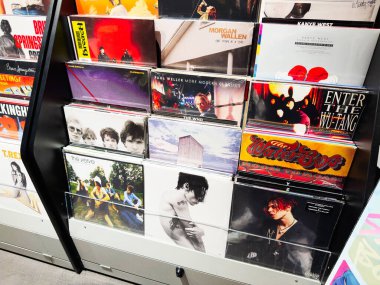 Stretford, İngiltere - 15 Kasım 2025: Manchester 'da bir mağazada retro müzik kültürü yakalayan vinil plaklar ve albüm kolları rafı.