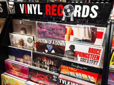 Stretford, İngiltere - 15 Kasım 2025: Cesur tipografi ve renkli sanat eserlerinin yer aldığı bir Manchester mağazasında bir dizi vinil plak.