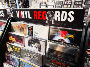 Stretford, İngiltere - 15 Kasım 2025: Klasik rock ikonları ve renkli albüm kapakları olan bir Manchester mağazasında vinil kayıt sergisi.