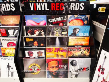 Stretford, İngiltere - 15 Kasım 2025: Manchester 'daki bir dükkanda çeşitli rock ve pop klasiklerinin parlak kollu sergilendiği bir raf.