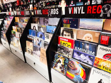 Stretford, İngiltere - 15 Kasım 2025: Manchester 'da renkli albüm kapakları ve açılı rafları olan işlek bir vinil mağazası.