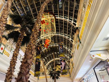 Stretford, İngiltere - 15 Kasım 2025: Parlak Trafford Merkezi Manchester alışveriş merkezi avlusu palmiye ağaçları, altın ışıklar, hediye süslemeleri ve bayram afişleri.