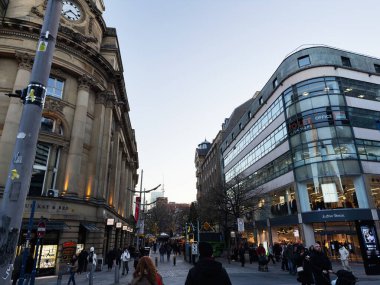 Manchester, İngiltere - 19 Kasım 2025: Manchester 'da kalabalık şehir caddesi eski mimari ve çağdaş perakende ve ofislerin karışımını gösteriyor.