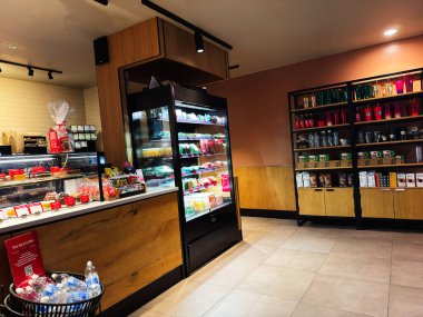 Manchester, İngiltere - 27 Kasım 2025: Cam ekran, içecek, atıştırmalık ve raflarla dolu Bright Manchester kafesi.