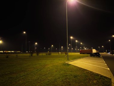 Polonya 'da sessiz bir gece sahnesi. Geniş bir park alanı, kamyonlar ve aydınlık sokaklar..